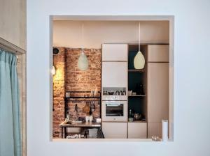 a kitchen with white appliances and a brick wall at Unique design, hype location! in Rīga