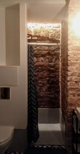 a bathroom with a brick wall and a tie at Unique design, hype location! in Rīga +5 photos
