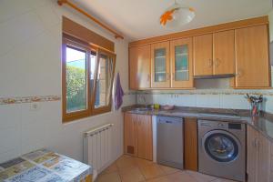 a kitchen with a washing machine and a window at La Senda Escogida in Torrelavega