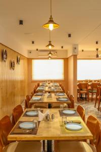 MundraClick Hotel Mundra的大型用餐室配有长桌和椅子 更多11张照片