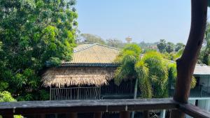 um edifício com um telhado de palha e uma palmeira em Shell Resort em Baía de Arugam