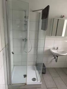 a shower with a glass door next to a sink at Monteurwohnung Haus Elbert 3 in Hagen