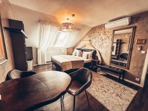 een slaapkamer met een bed en een tafel en stoelen bij Alfons Boutique Hotel in Praag
