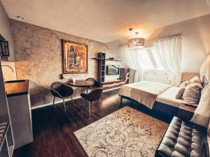 Alfons Boutique Hotel في براغ: غرفة نوم بسرير وطاولة وكراسي