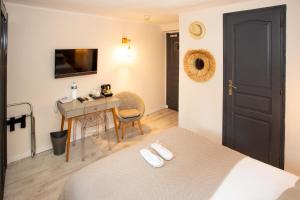 Habitación con cama, mesa y escritorio. en Villa Claudia Hotel Cannes Centre - Parking, en Cannes