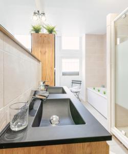 uma casa de banho com um lavatório e uma banheira em Appartement immeuble le bringer 180m2 em Marvejols