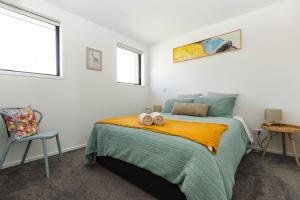 a bedroom with a bed with two towels on it at Modern 2 bedroom by Hagley Park in Christchurch