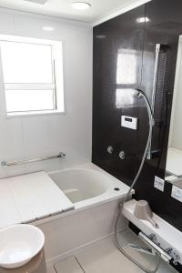 a bathroom with a tub and a toilet and a sink at Ittokashivacationrental nuevoL7 - Vacation STAY 83674v in Numata