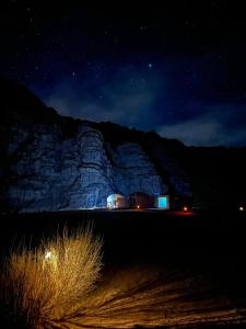 a night time view of a rock formation with two domes at Experience sleep under the star in Wadi Rum