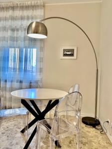 einen Tisch und Stühle in einem Zimmer mit einer Lampe in der Unterkunft City life Arsenale in Verona