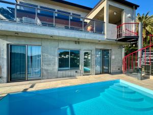 a house with a swimming pool in front of a house at Villa Sea-Esta Luxury heated pool villa built 2024 in Shimoda