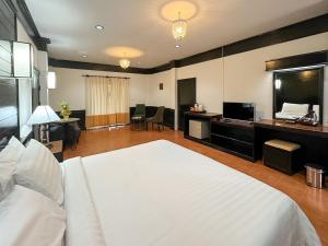 um quarto grande com uma cama branca e uma televisão em Silamanee Resort & Spa Hotel em Mae Sai