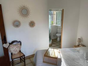 a bedroom with a bed and two mirrors on the wall at Appartement familial au cœur du village d’Olmeto in Olmeto +40 photos