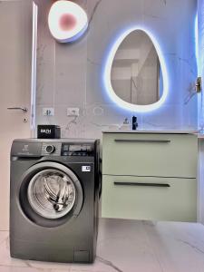 ein Badezimmer mit einer Waschmaschine und einem Spiegel in der Unterkunft City life Arsenale in Verona