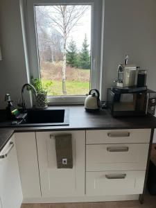 a kitchen counter with a sink and a window at Cudne Manowce ogrodzony domek na wyłączność wśród ciszy i natury u stóp Gór Izerskich in Giebułtów