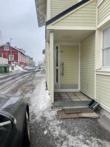 una puerta delantera de una casa con nieve en el suelo en Yksiö Pispalassa en Tampere