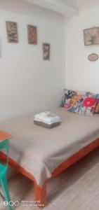 1 cama en la esquina de una habitación en Homey Studio Condo by Malou, en Calambá