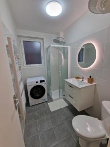 a bathroom with a sink and a washing machine at Halte Douillette au cœur de la Ville in Châteaudun