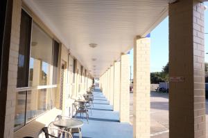 an empty hallway of a building with tables and chairs at Bamboo Motor Inn in Lakes Entrance