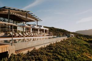 a pool with chairs and umbrellas on a hill at Khanyisa Mountain Lodge in Robertson