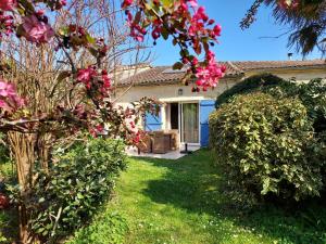 une maison avec des fleurs roses dans la cour dans l'établissement Gîte de Fenouil Le Cocon, à Civrac-de-Blaye