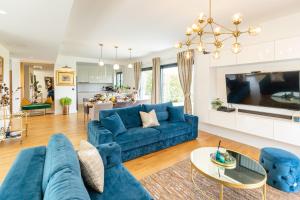 a living room with a blue couch and a tv at Villa Lux ZadarVillas in Zemuniki