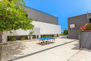 a ping pong table in front of a building at Villa Lux ZadarVillas in Zemuniki