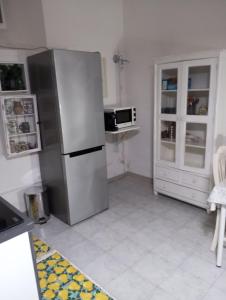 eine Küche mit einem Kühlschrank aus Edelstahl und einer Mikrowelle in der Unterkunft Domvs 84 in Torre Annunziata