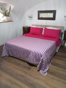 ein Schlafzimmer mit einem großen Bett mit rosa Kissen in der Unterkunft Domvs 84 in Torre Annunziata