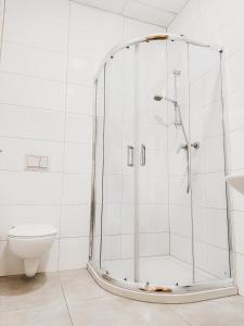 a shower in a white bathroom with a toilet at Ząbkowickie Centrum Sportu i Rekreacji Sp. z o. o. in Ząbkowice Śląskie