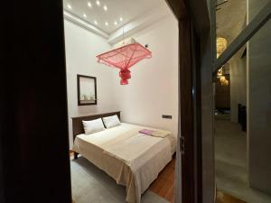 1 dormitorio con cama y lámpara de araña roja en 100 steps to beach weligama, en Weligama