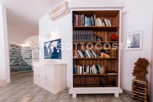 una stanza con una libreria piena di libri di Be Nature a Porto Cesareo