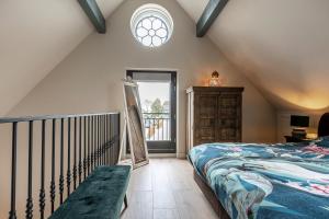 um quarto no sótão com uma cama e uma janela em The Willow Tree - Centrally located Barn em Lopik