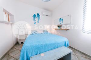 ein Schlafzimmer mit einem Bett mit einer blauen Decke in der Unterkunft Be Nature in Porto Cesareo