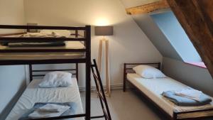 a room with two bunk beds in a attic at Auberge de jeunesse-La Hulotte in Montreuil-sur-Mer