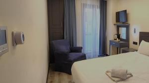 Habitación de hotel con cama y silla en Shishly Palace Hotel, en Estambul