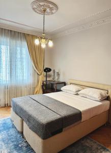 - une chambre avec un grand lit et un lustre dans l'établissement Luxurious 4BD/R flat Nışantaşı, à Istanbul