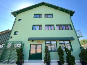 un grand bâtiment vert avec des fenêtres dans l'établissement Casa Verde, à Videle