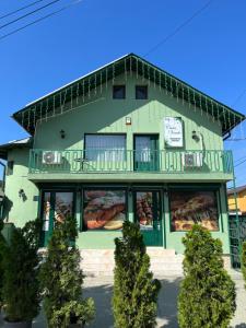 a green building with a window display of bread at Casa Verde in Videle