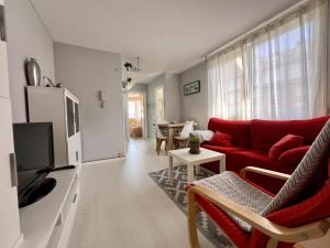 a living room with a red couch and a table at Apartamento Somo Puerto in Somo