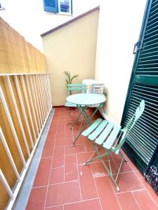 eine Terrasse mit 2 Stühlen und einem Tisch auf dem Balkon in der Unterkunft I Marmi New Royal Design Apartment in Livorno