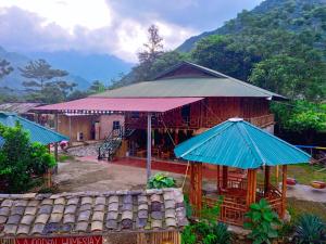 a small building with blue umbrellas in front of it at Du Gia Wooden Homestay in Làng Cac