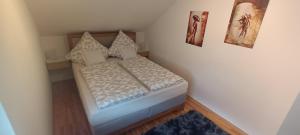 a small bed in a room with pictures on the wall at Ferienwohnung Elisabeth Waxweiler in Waxweiler
