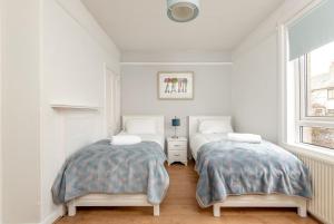 セント・アンドルーズにあるBoase Avenue - No 24 - St Andrewsの白い壁のベッドルーム(ベッド2台、窓付)