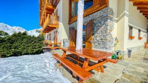 a wooden picnic table on the side of a building at Cianfuran Panorama - Maison dOc in Bardonecchia