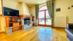 a living room with a fireplace and a tv at Cianfuran Panorama - Maison dOc in Bardonecchia