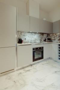 uma cozinha com armários brancos e um forno preto em Bufalini Boutique Apartment em Florença