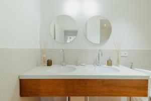 uma casa de banho com um lavatório e 2 espelhos em Bufalini Boutique Apartment em Florença
