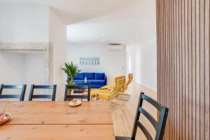 ein Esszimmer mit einem Holztisch und Stühlen in der Unterkunft Cozy Coastal Getaway 3BR Apartment in Estoril in Estoril