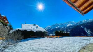 a snow covered roof of a building with mountains in the background at Cianfuran Panorama - Maison dOc in Bardonecchia